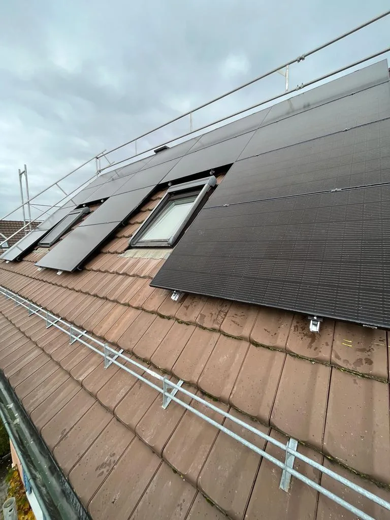 Solarmodule neben Dachfenstern auf einem Ziegeldach