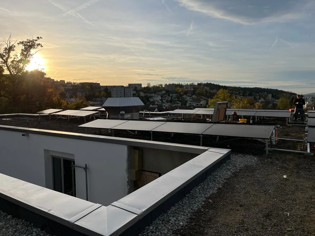 Photovoltaikanlage auf einem flachen Gebäudedach bei Sonnenuntergang