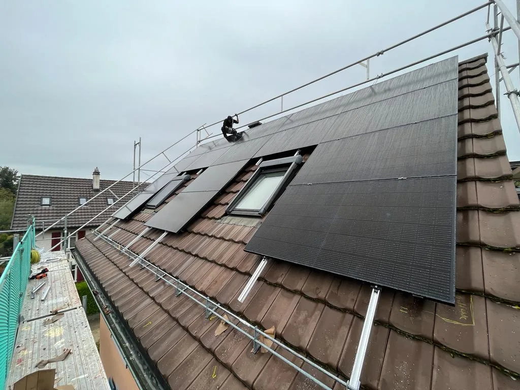 Montierte Solarmodule auf einem Ziegeldach mit Dachfenstern